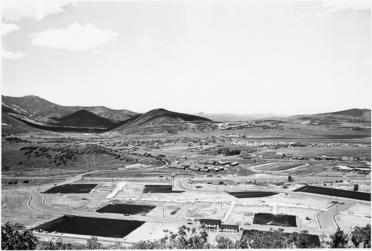 Lewis Baltz, Looking north from Masonic Hill toward Quarry Mountain. In foreground, new parking lots on land between West Sidewinder Drive and State Highway 248. In middle distance, from left: Park Meadows, subdivisions 1, 2, and 3; Holiday Ranchette Estates; Raquet Club Estates. At far distance on left, Parkwest Ski Area, 1980, #1 from Park City 