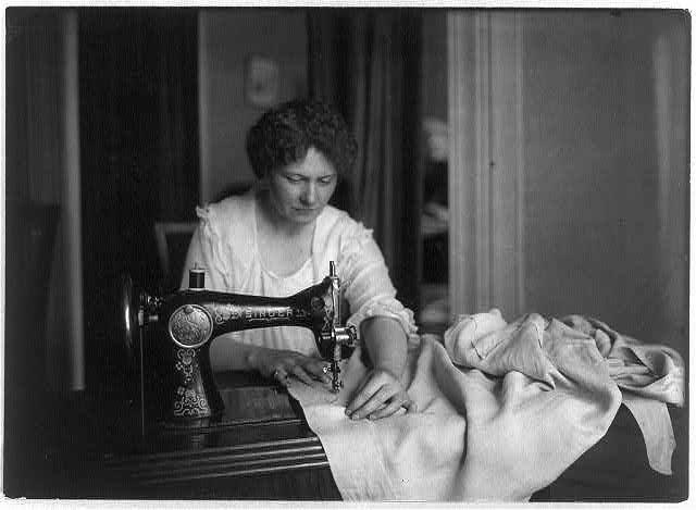 Femme en train de coudre avec une machine de la marque Singer (entre 1917 et 1918] Archives de la Bibliothèque du Congrès des États-Unis – https://www.loc.gov/item/2005696171/. (Accès le 15 décembre 2016.)